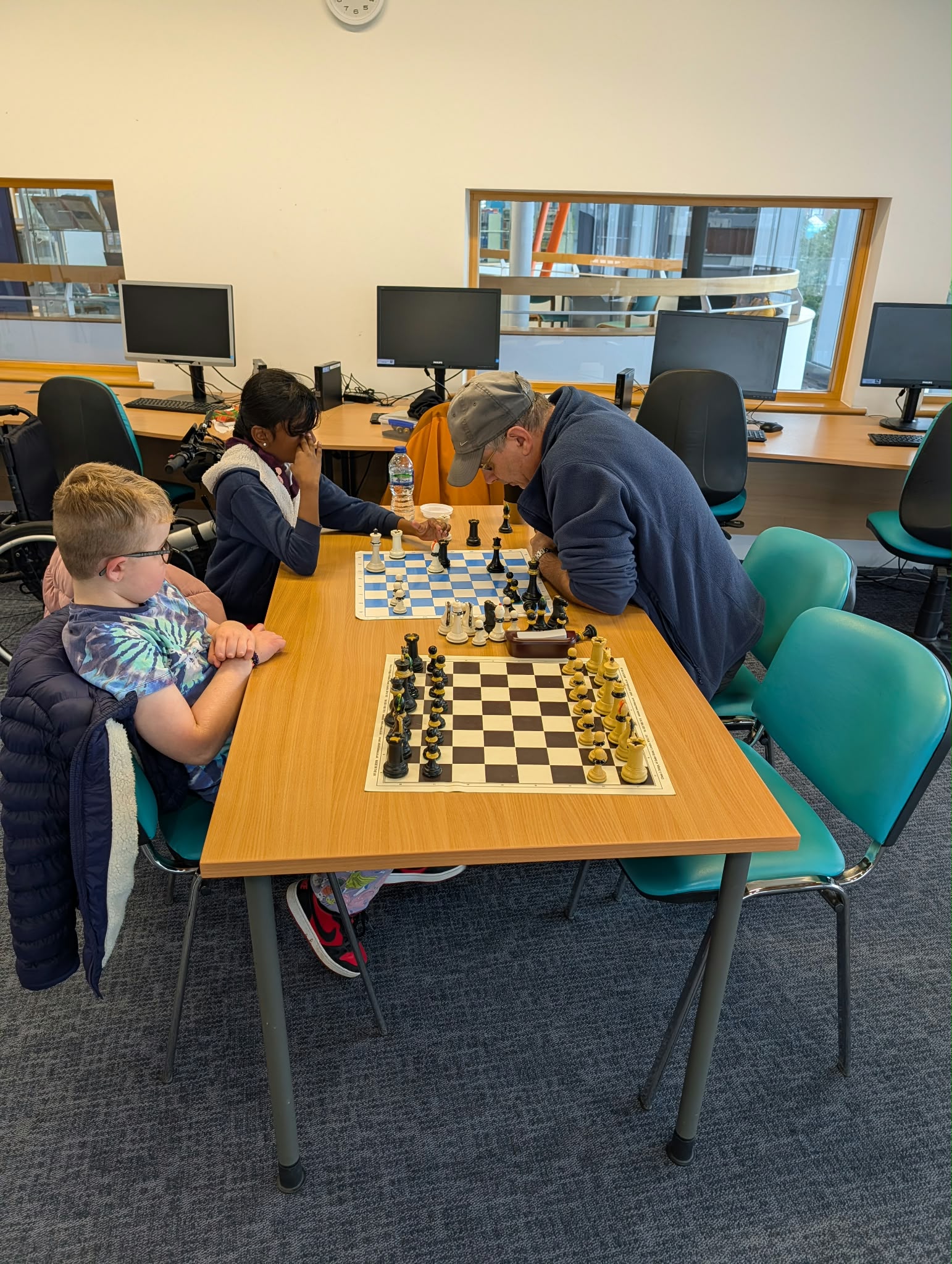 Group of kids around a board, smiling